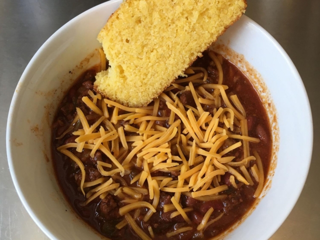 Home made chili, some cheddar cheese and corn bread.